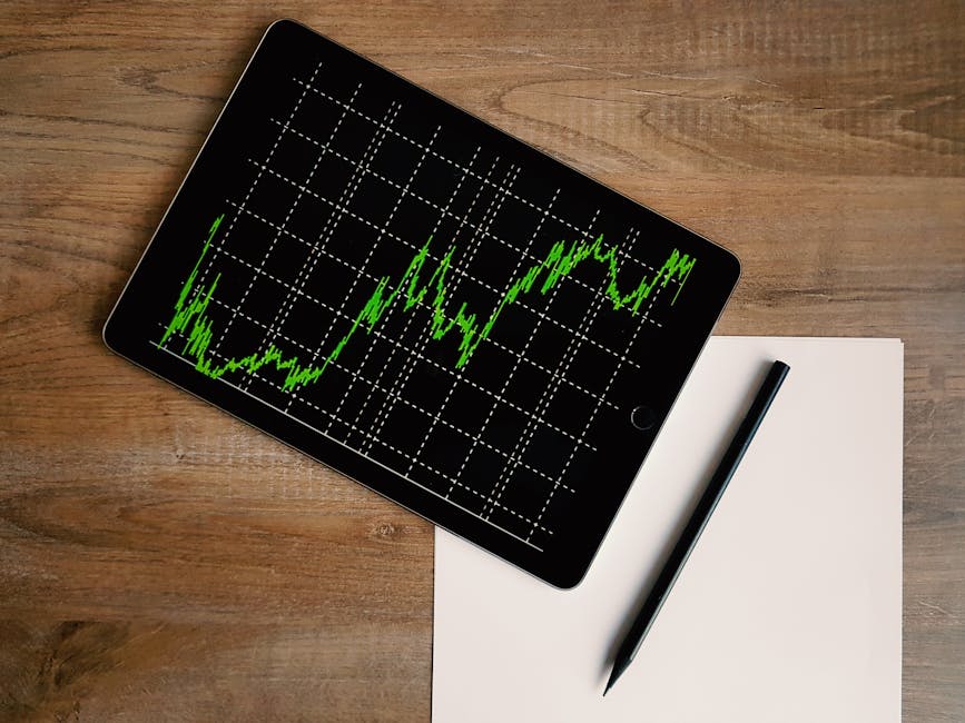 Flatlay of an iPad displaying stock market graph on a wooden desk